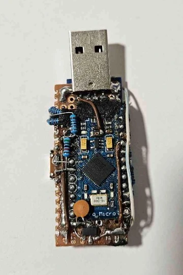 Bottom side of the RISE prototype showing the blue ATmega32U4 Pro Micro board, 16 MHz crystal, jumper wires, ceramic capacitor, and SOT-223 3.3V regulator.